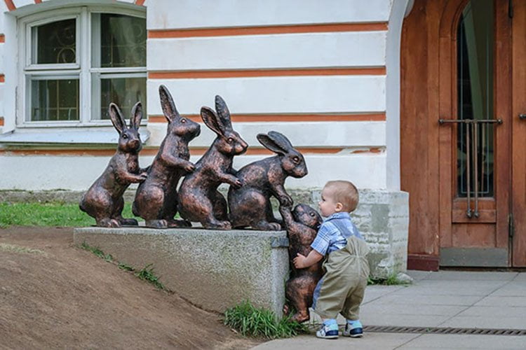 Niño no sabe que el conejo es una estatua Niño no sabe que el conejo es una estatua