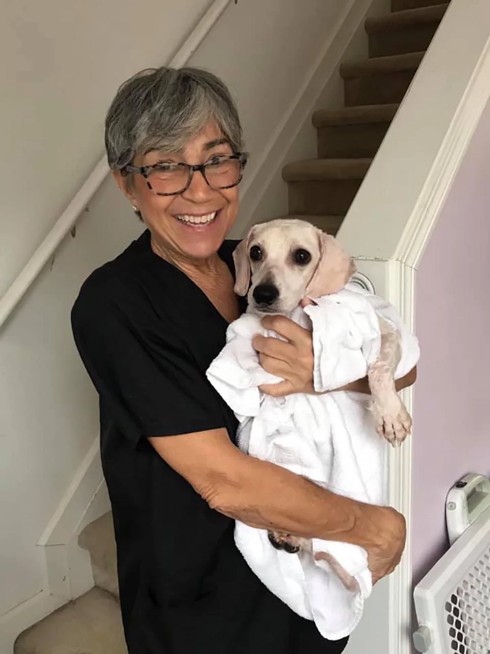 Perrito rescatado de un criadero ni siquiera sabía cómo dormir acostado 6 señora sostiene perrito rescatado