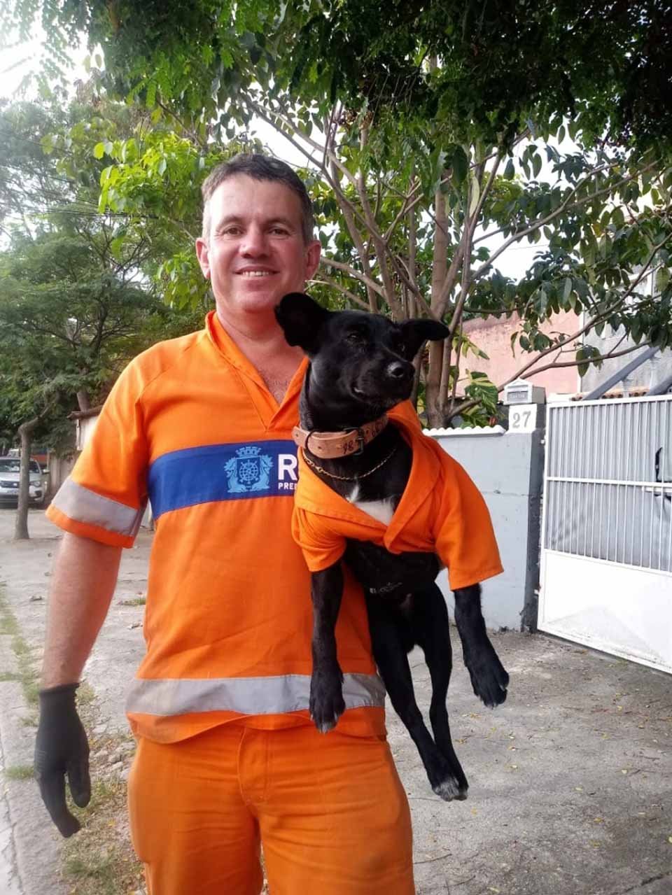 Perro adoptado por un barrendero lo acompaña al trabajo usando un adorable uniforme 11 Hombre carga a su perrito