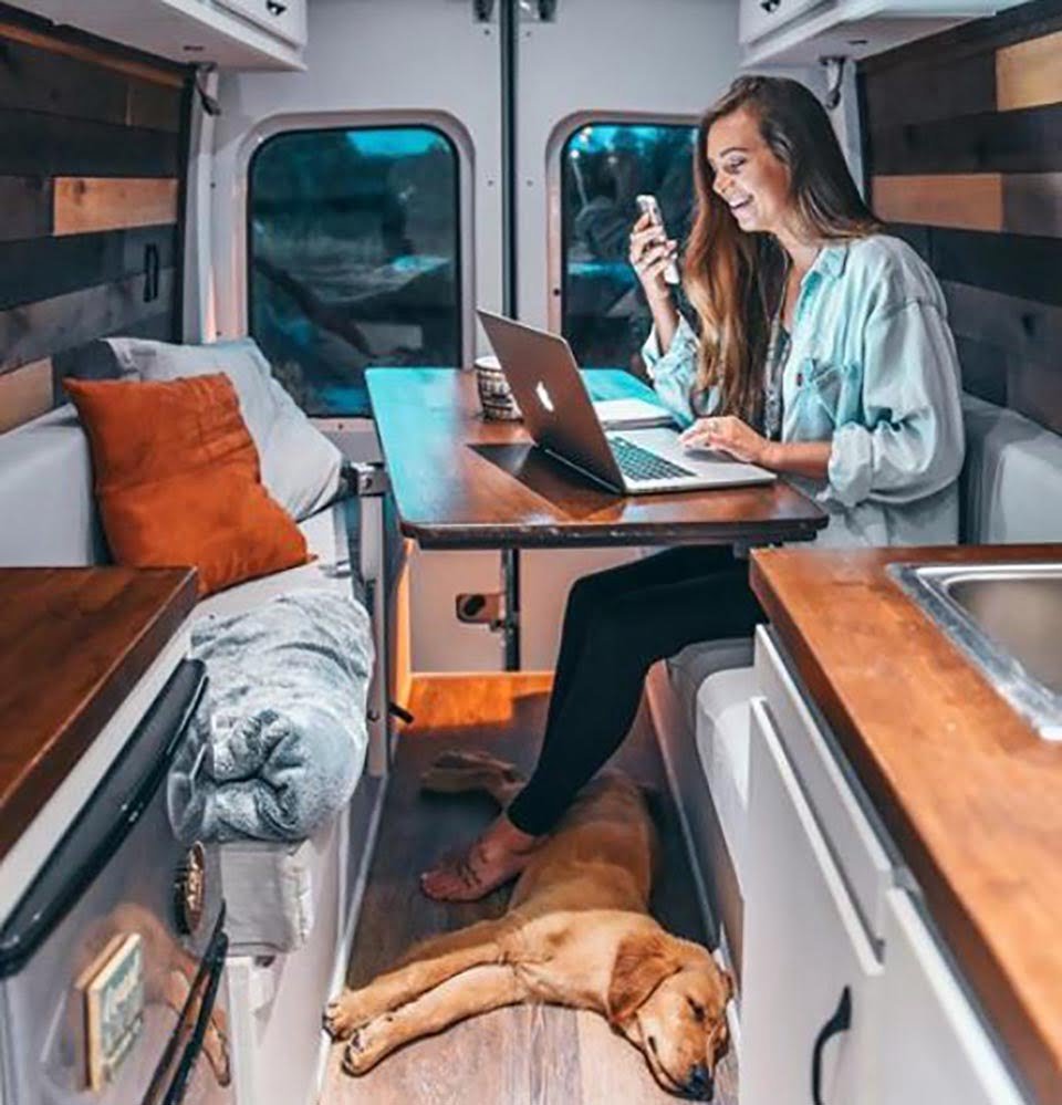 Mujer termina con su novio y deja su trabajo para viajar en su furgoneta con su perrita 12 Mujer en su laptop desde su furgoneta