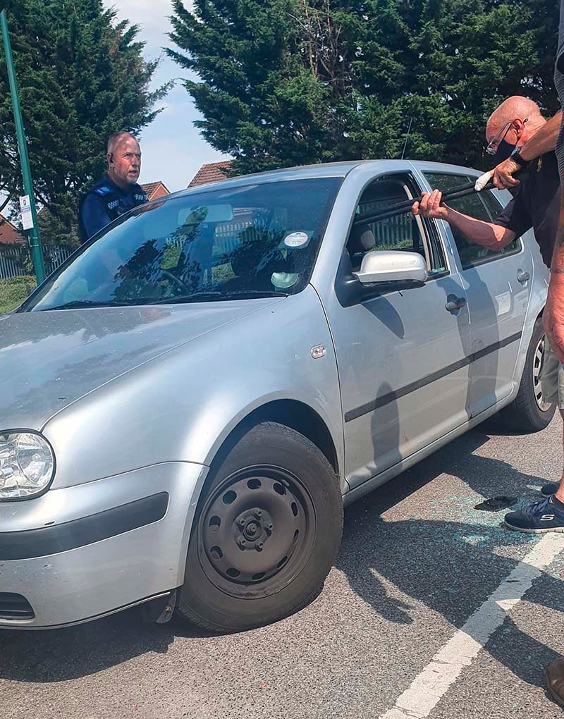 Hombre salva a un perro encerrado en un auto caliente rompiendo la ventana con un hacha 14 Policía llega al rescate