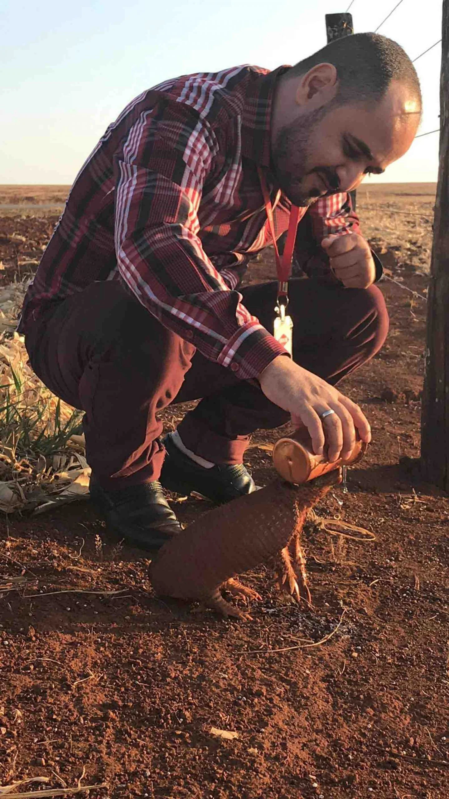 Hombre da agua a armadillo sediento