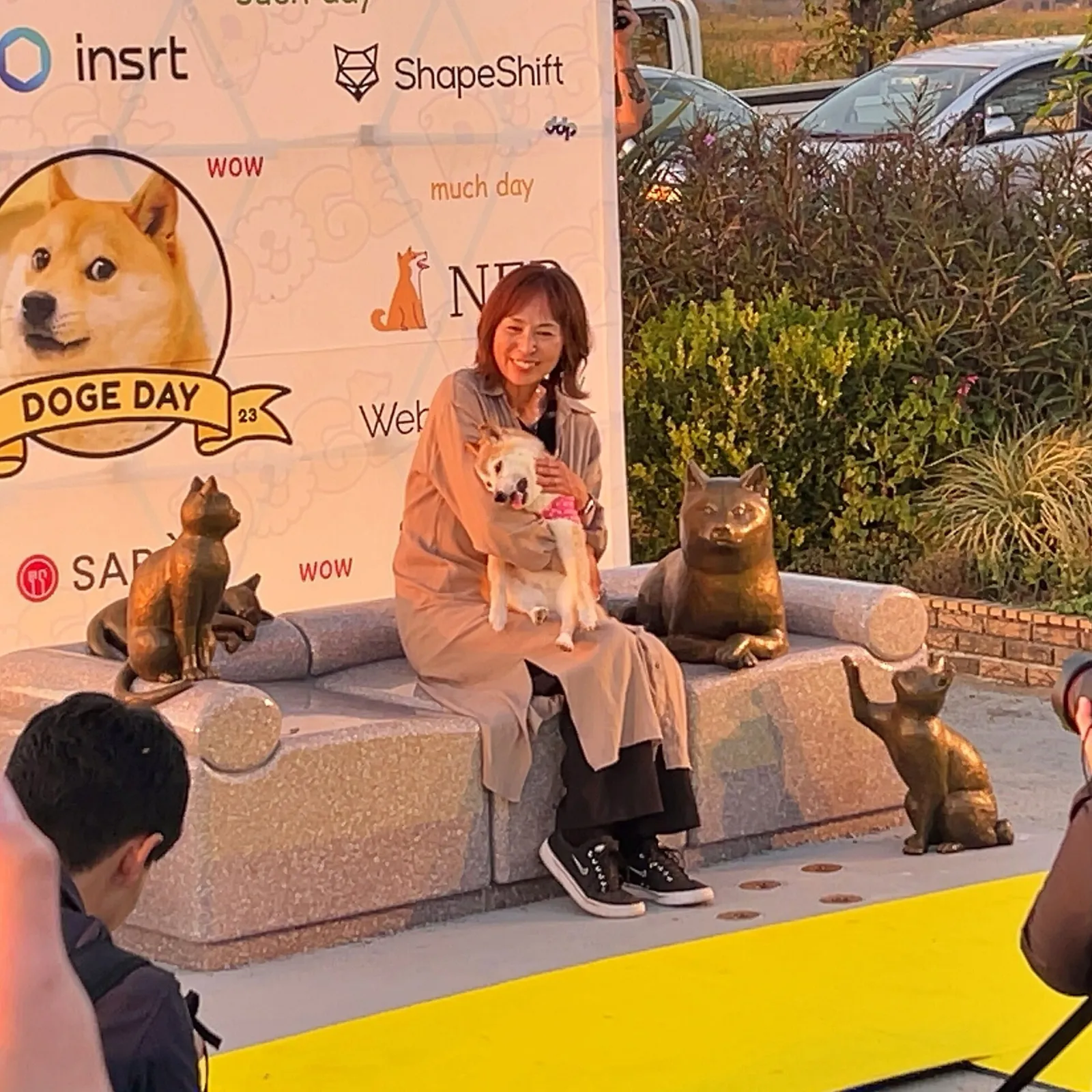Kabosu, una shiba inu, sentada junto a Atsuko Sato sobre el monumento de bronce y piedra dedicado a ella en Sakura, Japón