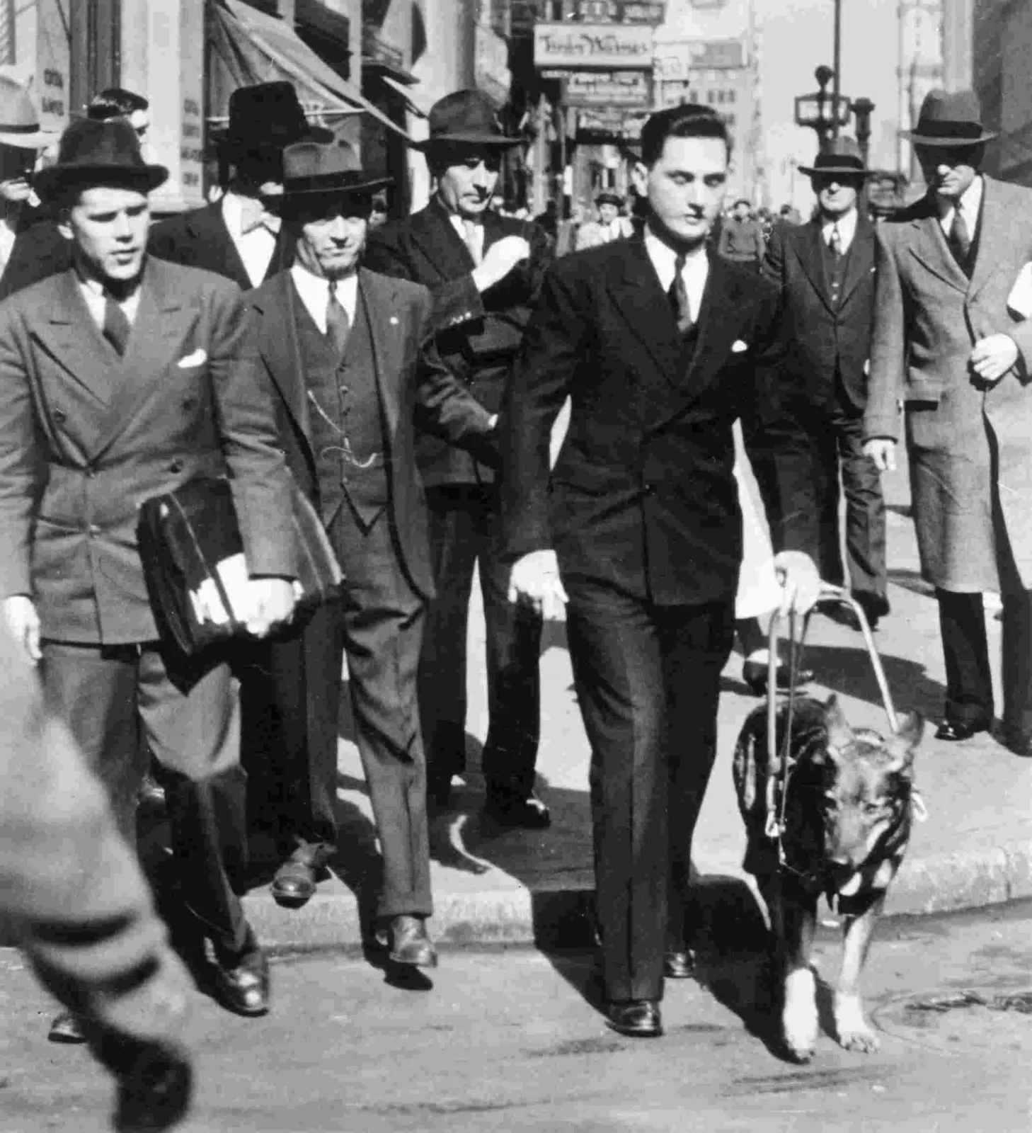 Nueva York, 1928: un periodista retó a un joven ciego a cruzar una avenida con su pastora alemana 3 Fotografía de prensa en blanco y negro de Morris Frank y su pastora alemana Buddy cruzando una calle con tráfico en Nueva York, en 1928