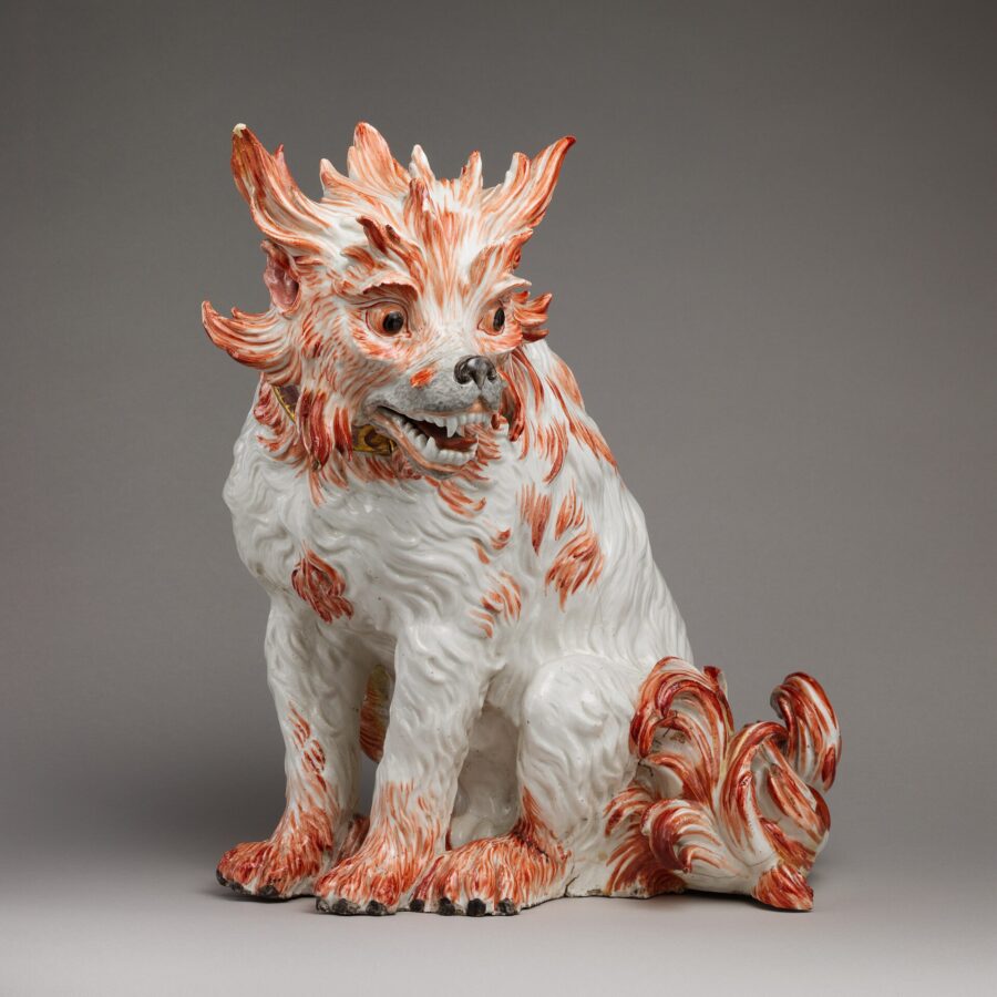 Figura de porcelana blanca con manchas naranjas de un perro boloñés sentado